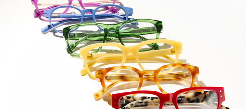 rainbow colored selection of eyeglasses lined up against white background