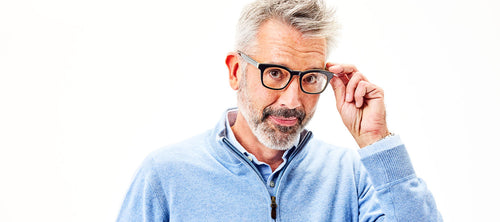 gray haired main in a blue collared shirt wearing glasses