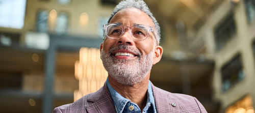 man looking upwards wearing transparent frame glasses
