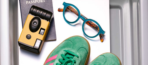 glasses, shoes, camera and passport in a TSA bin
