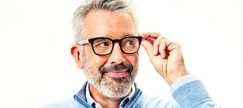 man holding one side of his wide framed glasses
