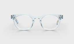 Square-shaped blue crystal acetate eyeglasses with shiny finish and subtle retro-inspired frame on light gray background
