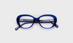 eyebobs oval eyeglasses in cobalt blue, laid flat with temples visible