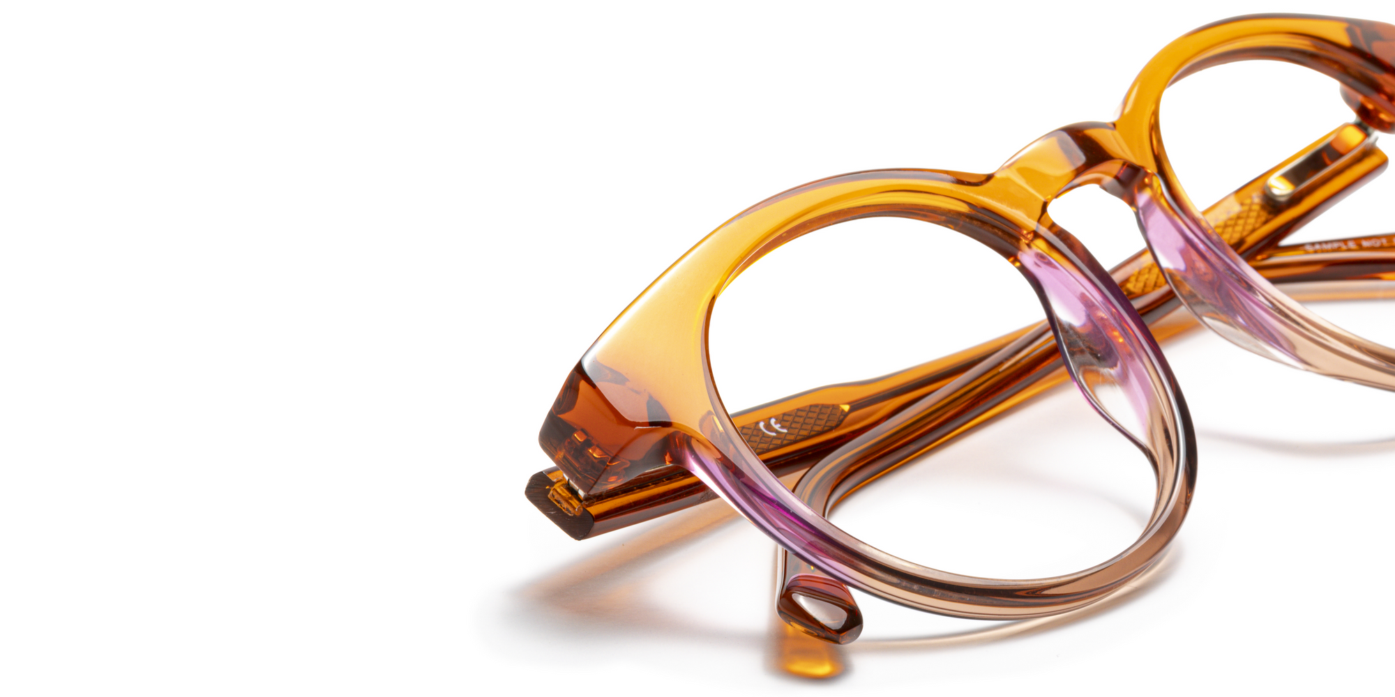 Close-up of Italian-designed acetate reading glasses with a warm amber to soft purple gradient and smooth polished finish