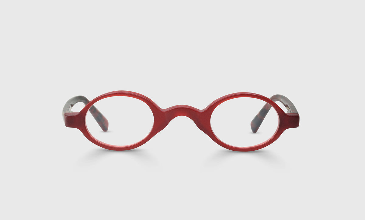 Narrow oval unisex glasses with matte red front and red temples flecked with black on light gray background