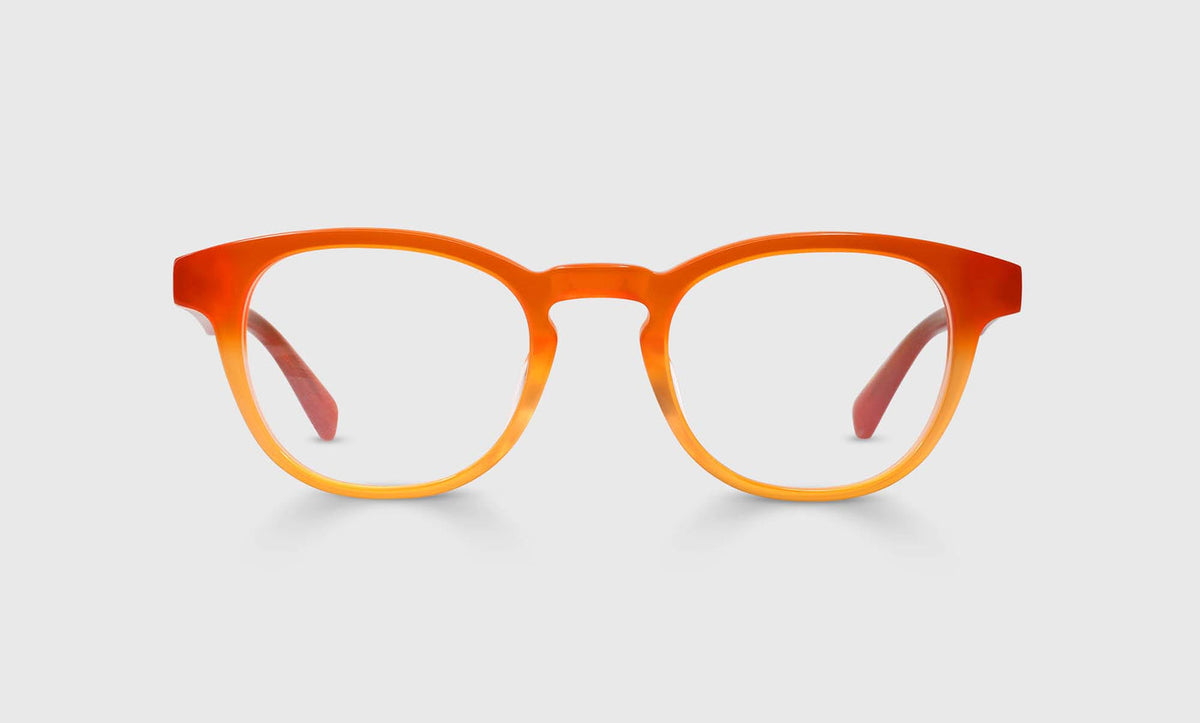 Round eyeglasses with gradient acetate frame fading from bright orange to soft peach on a light gray backdrop