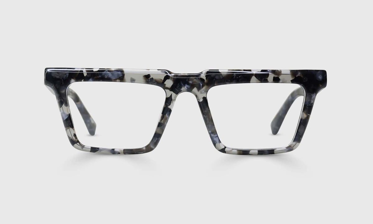 Wide square prescription eyeglasses with black and grey marbled acetate frame on plain light gray background