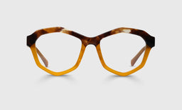 Geometric acetate eyeglasses with amber tortoise pattern on top and solid gold frame bottom on a gray background