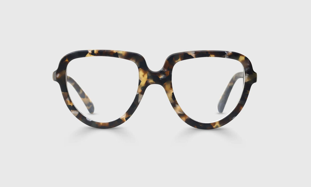 Narrow oval eyeglasses with glossy tortoise acetate frame and temples on a plain light gray background