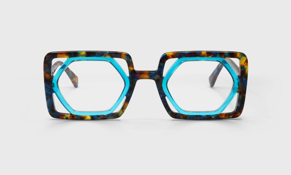 Hexagonal eyeglasses with cool aquamarine inner frame and textured tortoiseshell umber pattern on bold outer rims